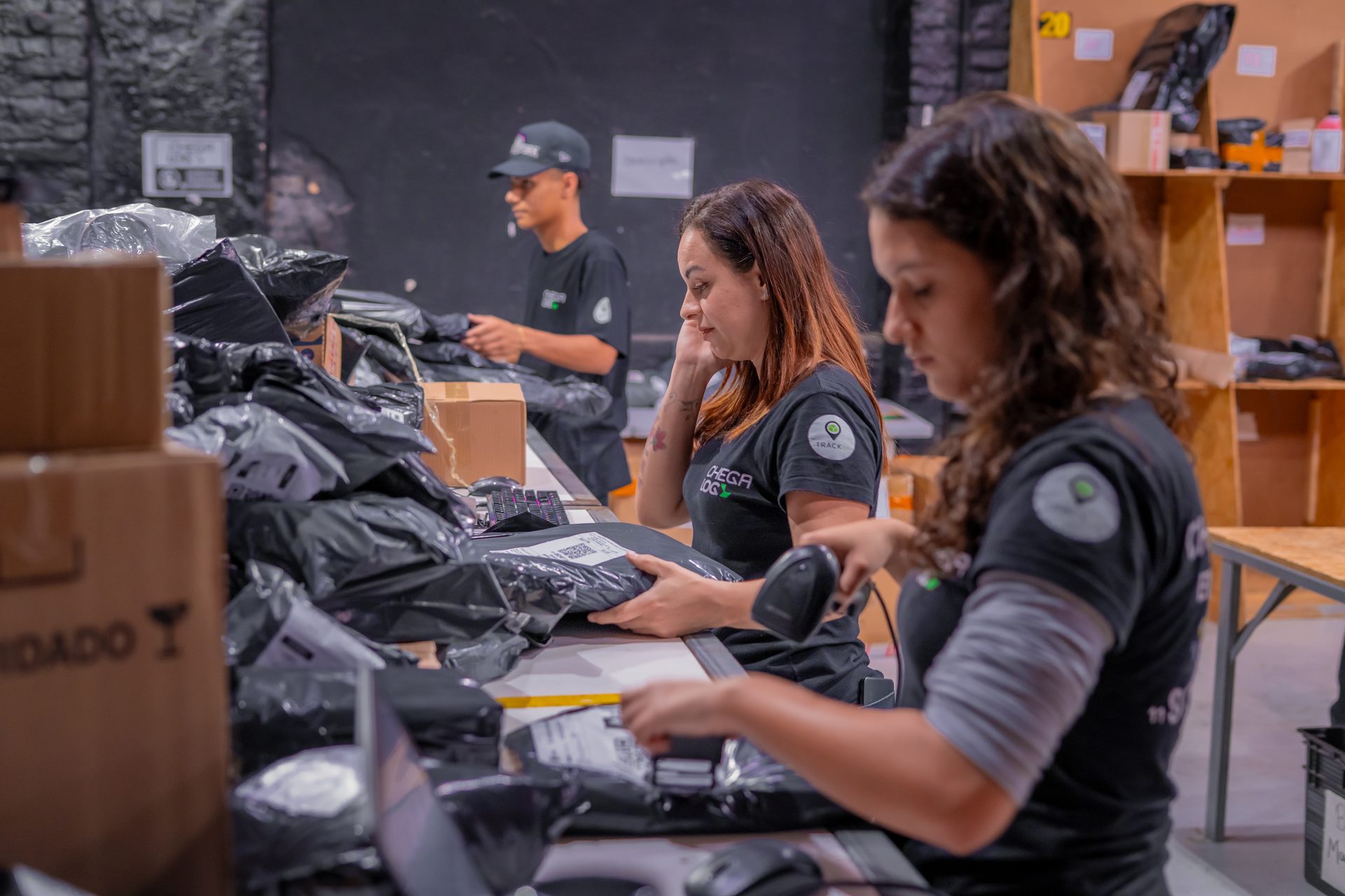 Equipe da ChegaLog organizando caixas de pedidos na área de triagem