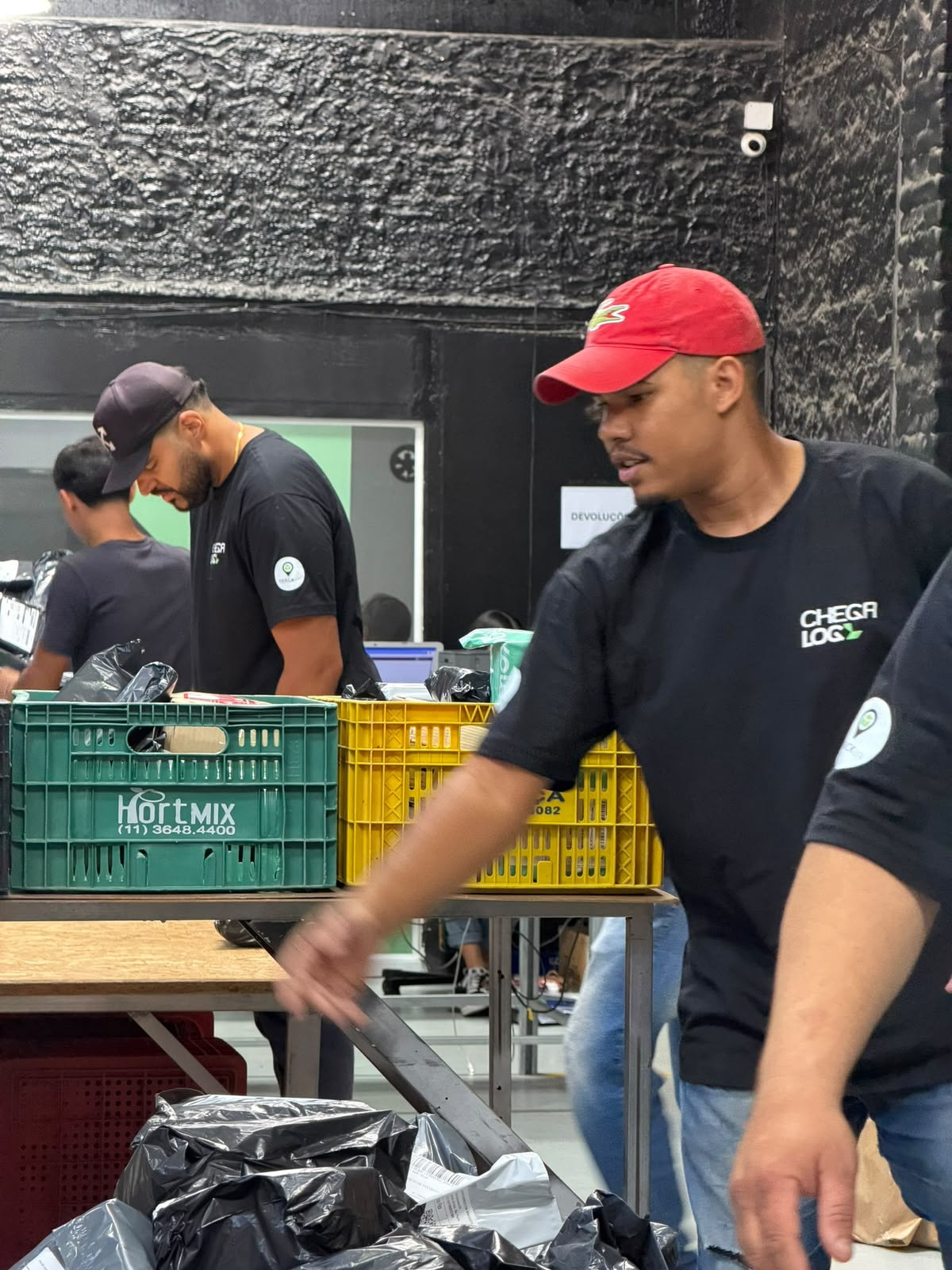 Equipe da ChegaLog organizando caixas de pedidos na área de triagem