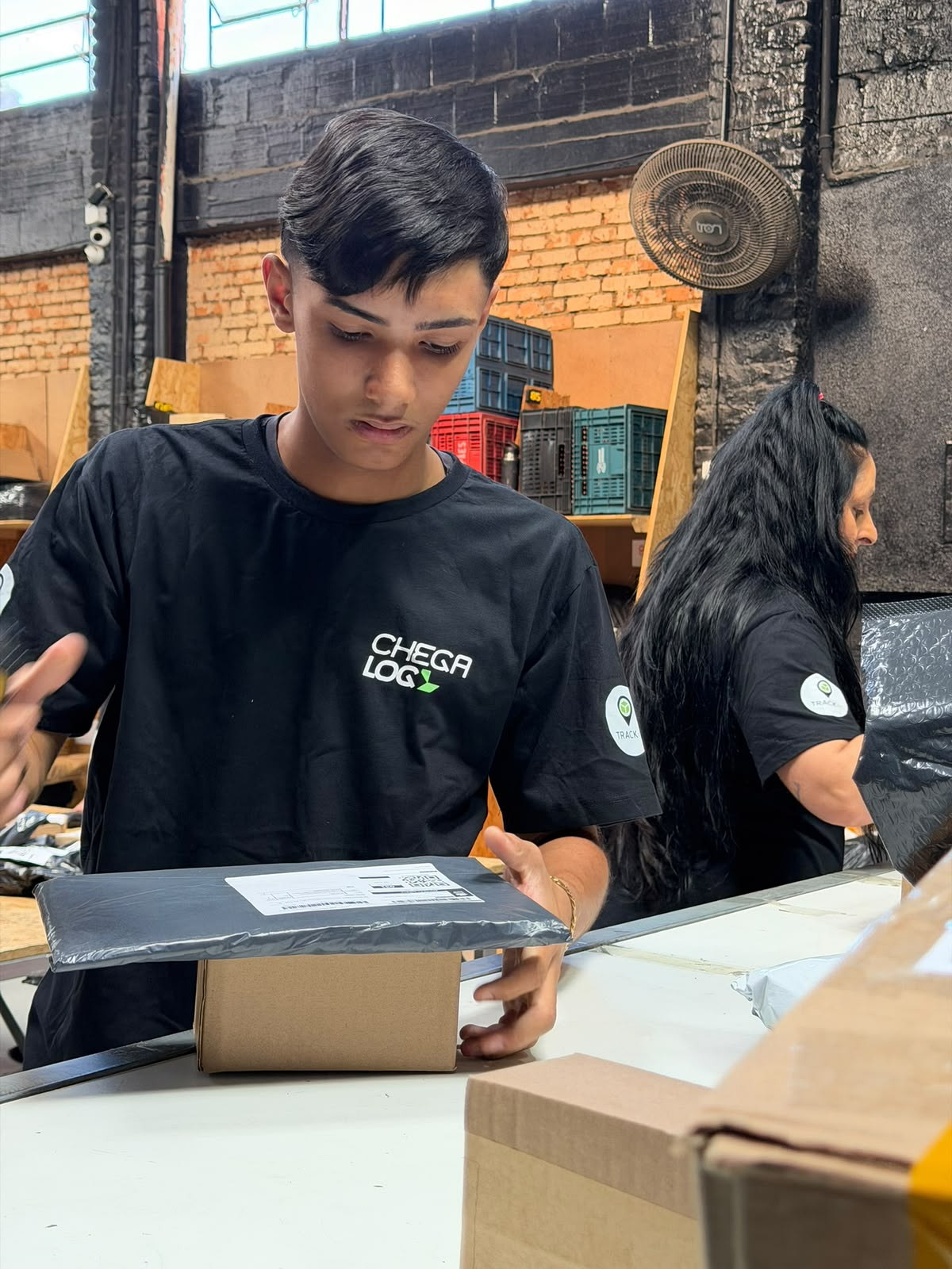 Colaborador da ChegaLog embalando um pedido na bancada de expedição