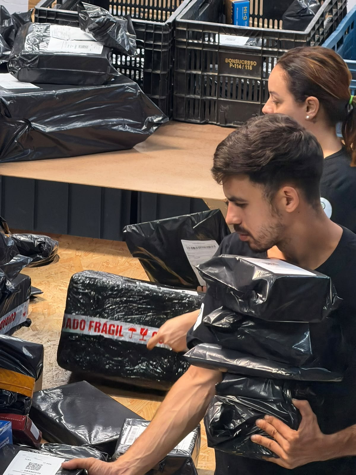 Equipe ChegaLog conferindo pacotes com etiqueta de frágil na separação